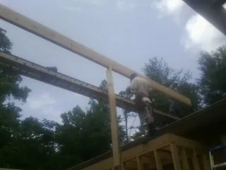 Carpenter setting a ridge beam over a new addition frame — Ice Dam Removal by Roofing Brothers in Thomson