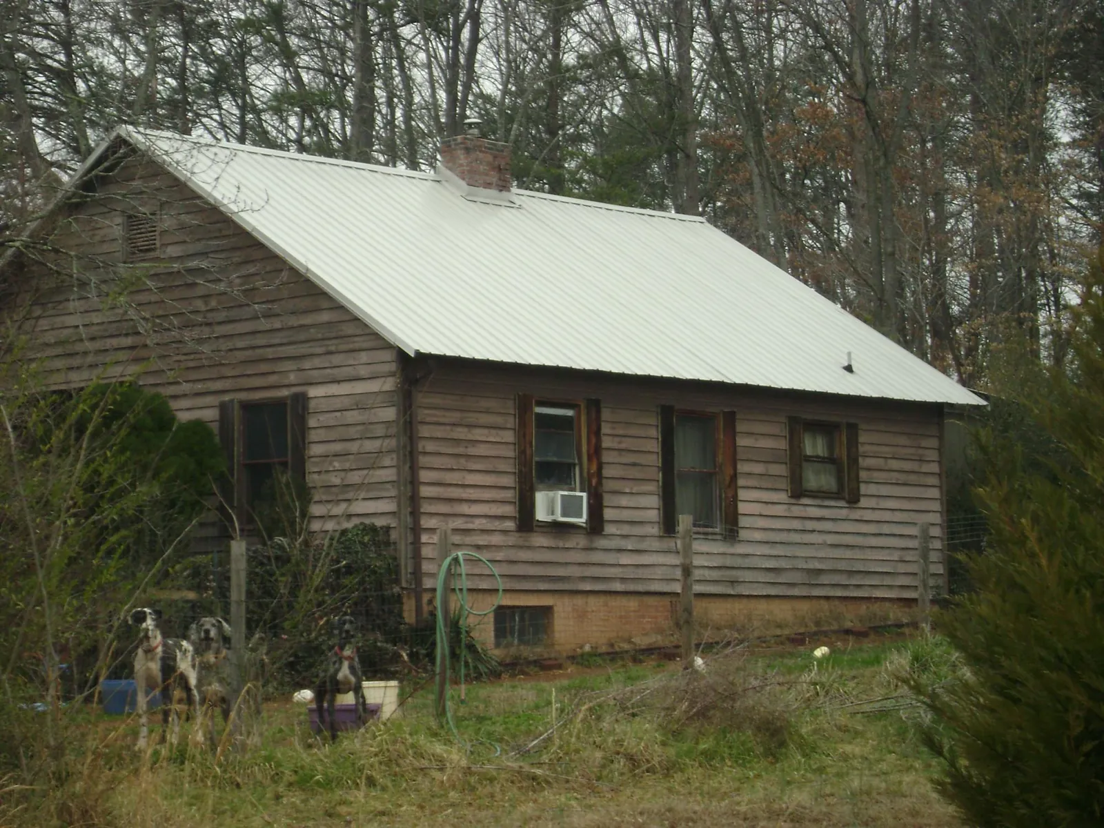 White metal roof on an old wood sided farmhouse, from a Metal Roof Installation job in Thomson
